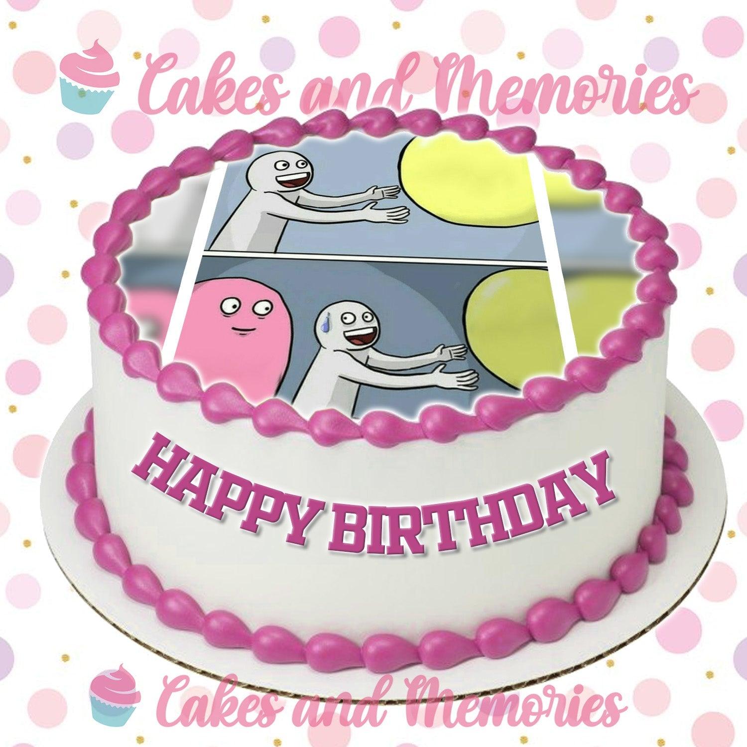 White round cake with pink icing borders and a funny meme printout on top featuring a character and a yellow ball.
