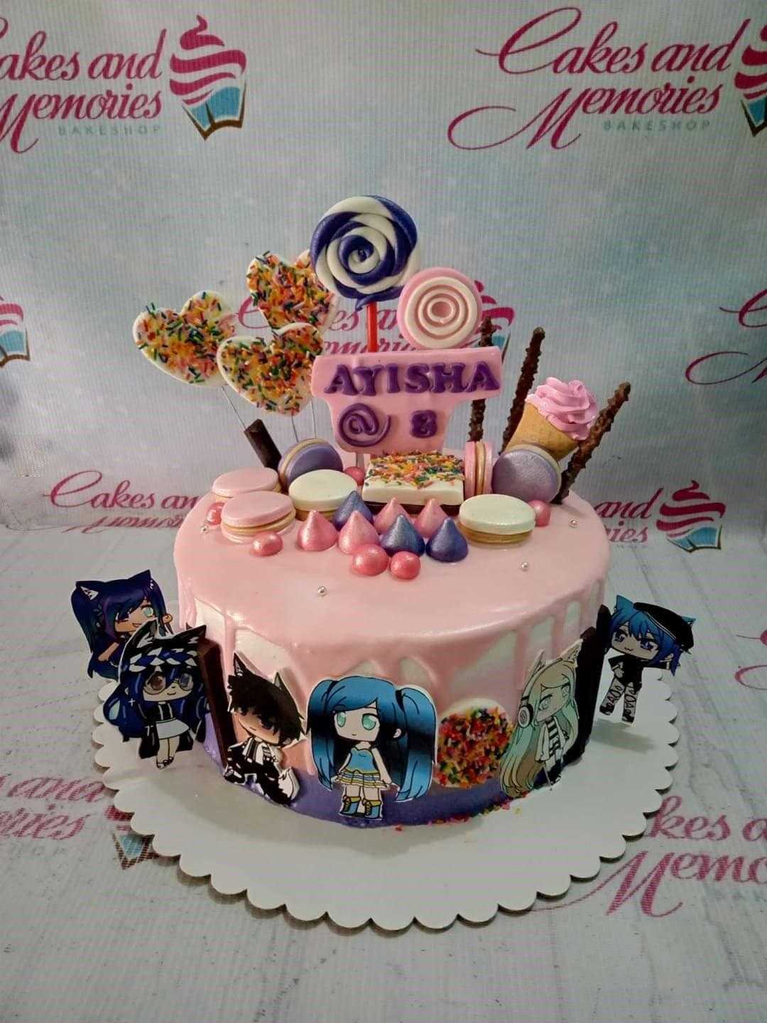 Pink drip cake with Gacha Life character printouts, macarons, lollipops, and a personalized name topper for Ayisha's 8th birthday.