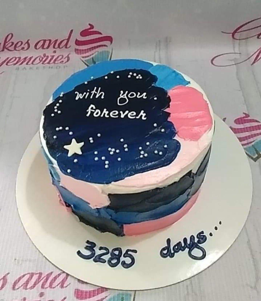 Bento cake with a dark blue galaxy-themed palette knife icing design, white stars, and a heartfelt message for an anniversary.