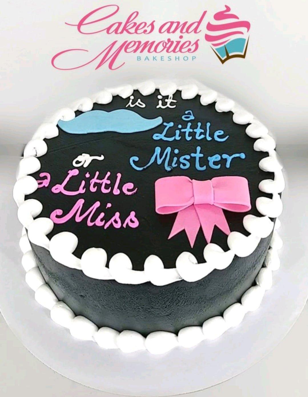 Black gender reveal cake with white icing borders, a blue mustache, and a pink bow featuring the message 'is it a Little Mister or a Little Miss'.