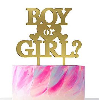 Gender reveal cake with pink and blue textured icing and a gold Boy or Girl topper.