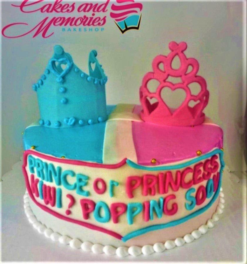 Gender reveal cake with blue and pink crowns and a message asking Prince or Princess Kiwi Popping Soon