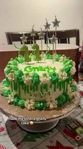 Green and white 1-tier birthday cake with green icing drips, star candles, and number 11 toppers.