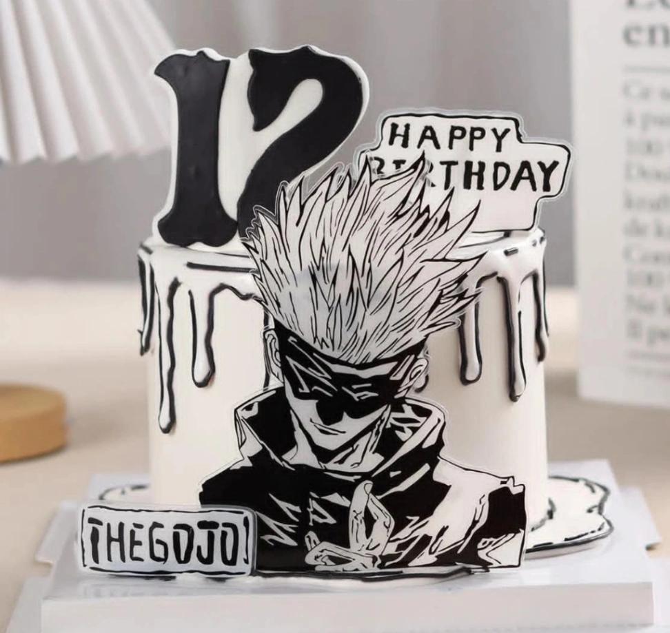 Black and white anime themed cake featuring Gojo Satoru from Jujutsu Kaisen with comic style 2D drip and character printouts.
