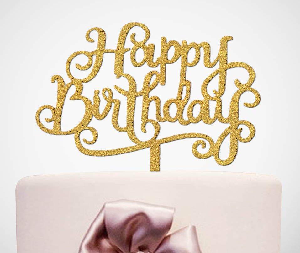 White minimalist cake with a large gold glitter Happy Birthday cardstock topper and a pink satin ribbon bow.