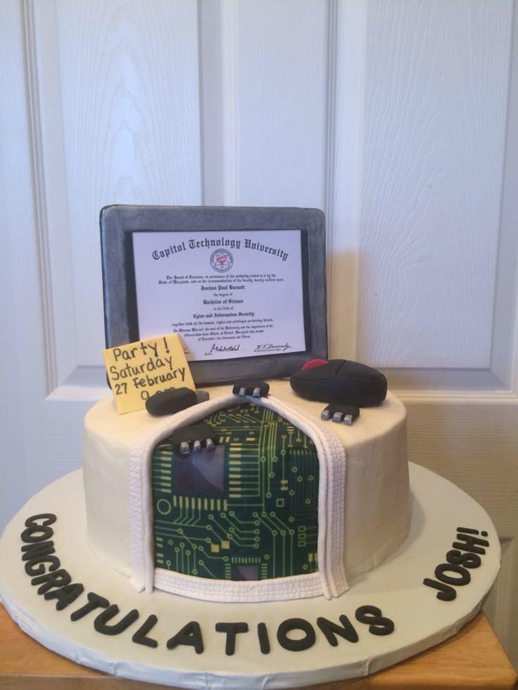 White fondant cake with a computer monitor topper displaying a university diploma and a circuit board design on the side.