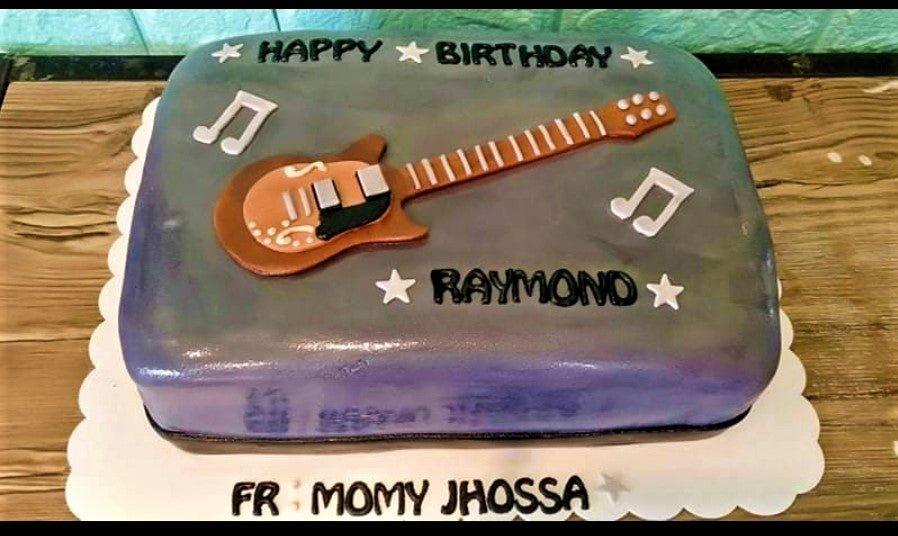 Rectangle purple and gray fondant guitar cake with musical notes and stars for Raymond's birthday.