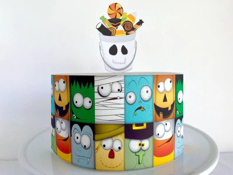 Halloween monster themed cake with colorful character faces and a candy bucket topper.