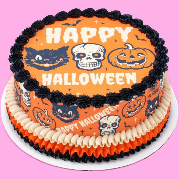 Orange Halloween cake with black and white skull, pumpkin, and cat graphics, featuring black and orange ruffled icing borders.