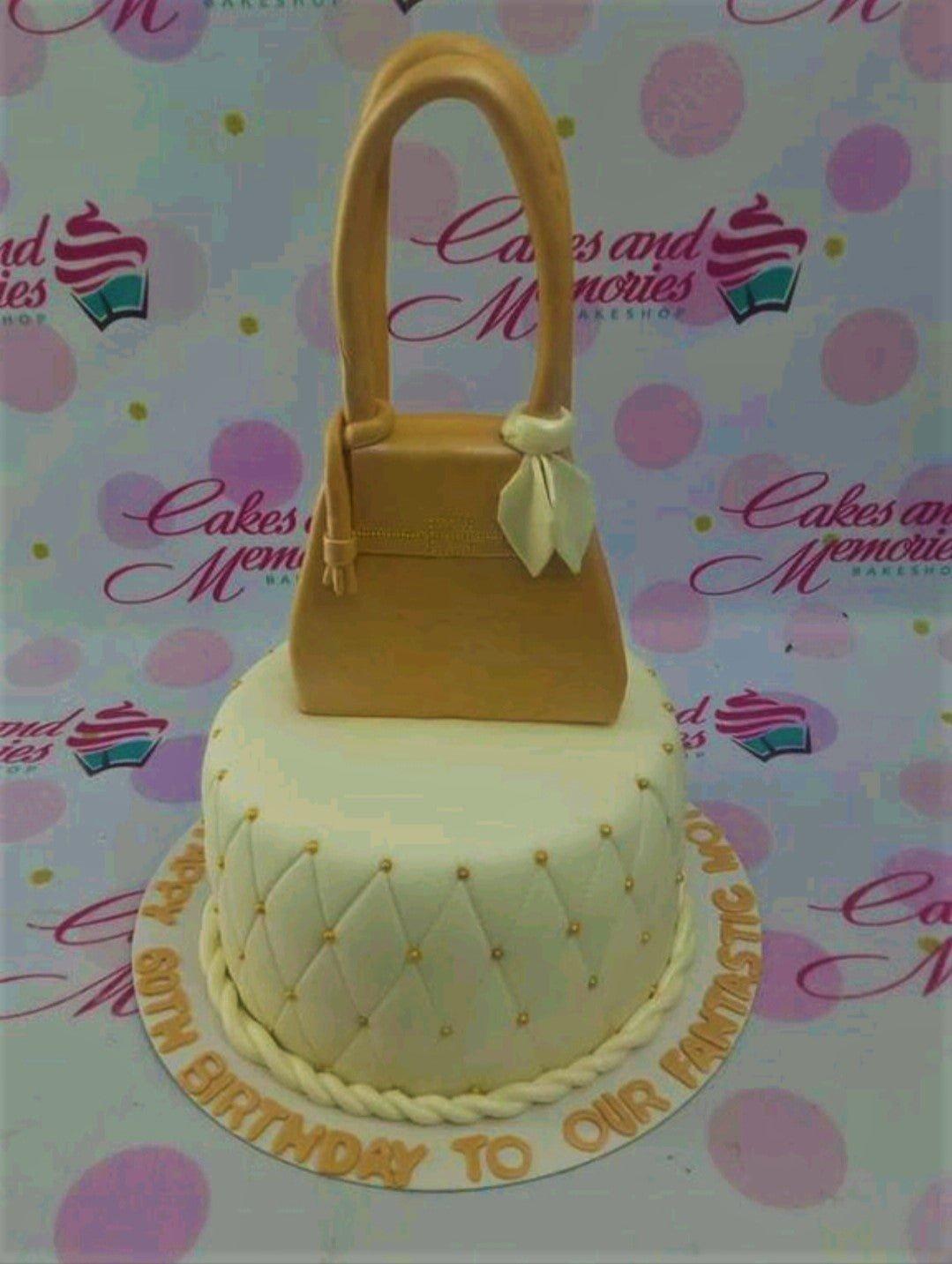 Elegant tan handbag fondant cake with quilted pattern and gold dragees for a 60th birthday celebration.