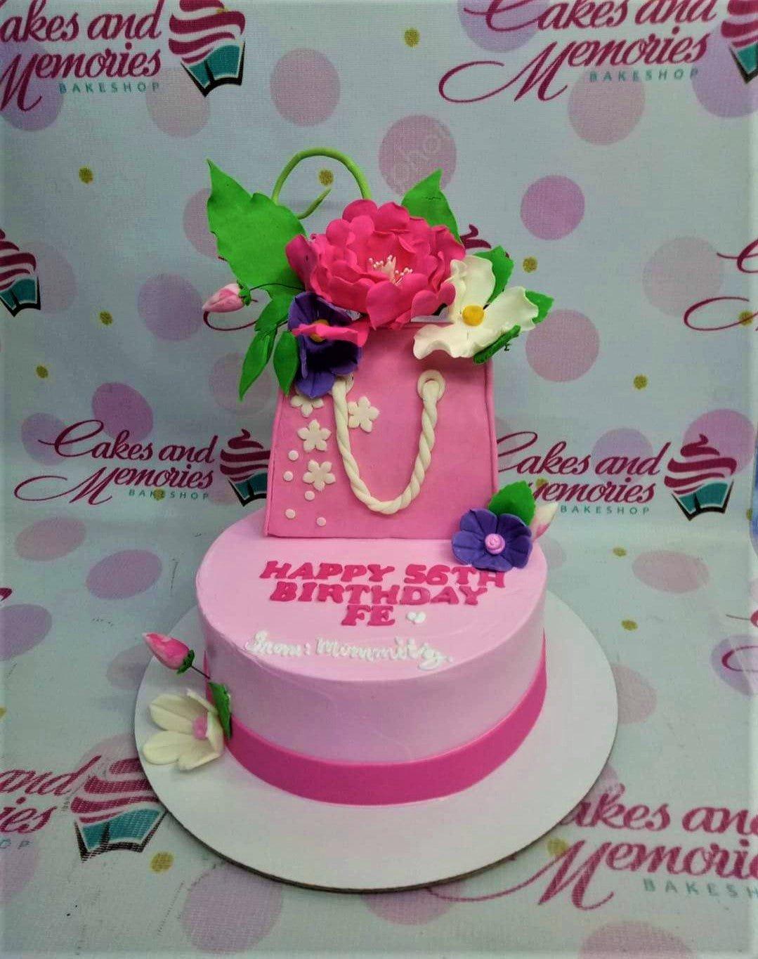 Pink 1-tier birthday cake featuring a 3D fondant pink handbag topper with edible flowers and a personalized message.