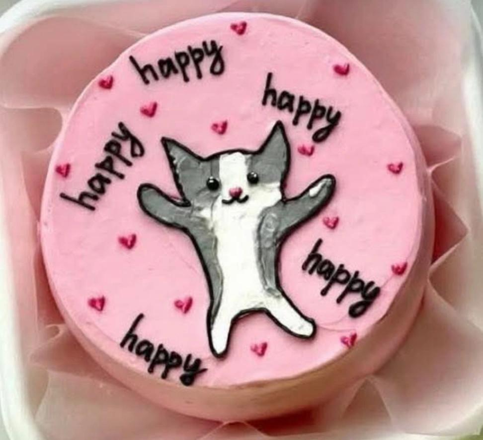 Pink bento cake with a hand-piped grey and white cat illustration and small red hearts
