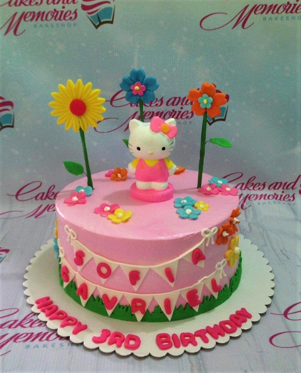 Pink Hello Kitty birthday cake with colorful fondant flowers and a personalized name banner for Sofia Gavriel's 3rd birthday.