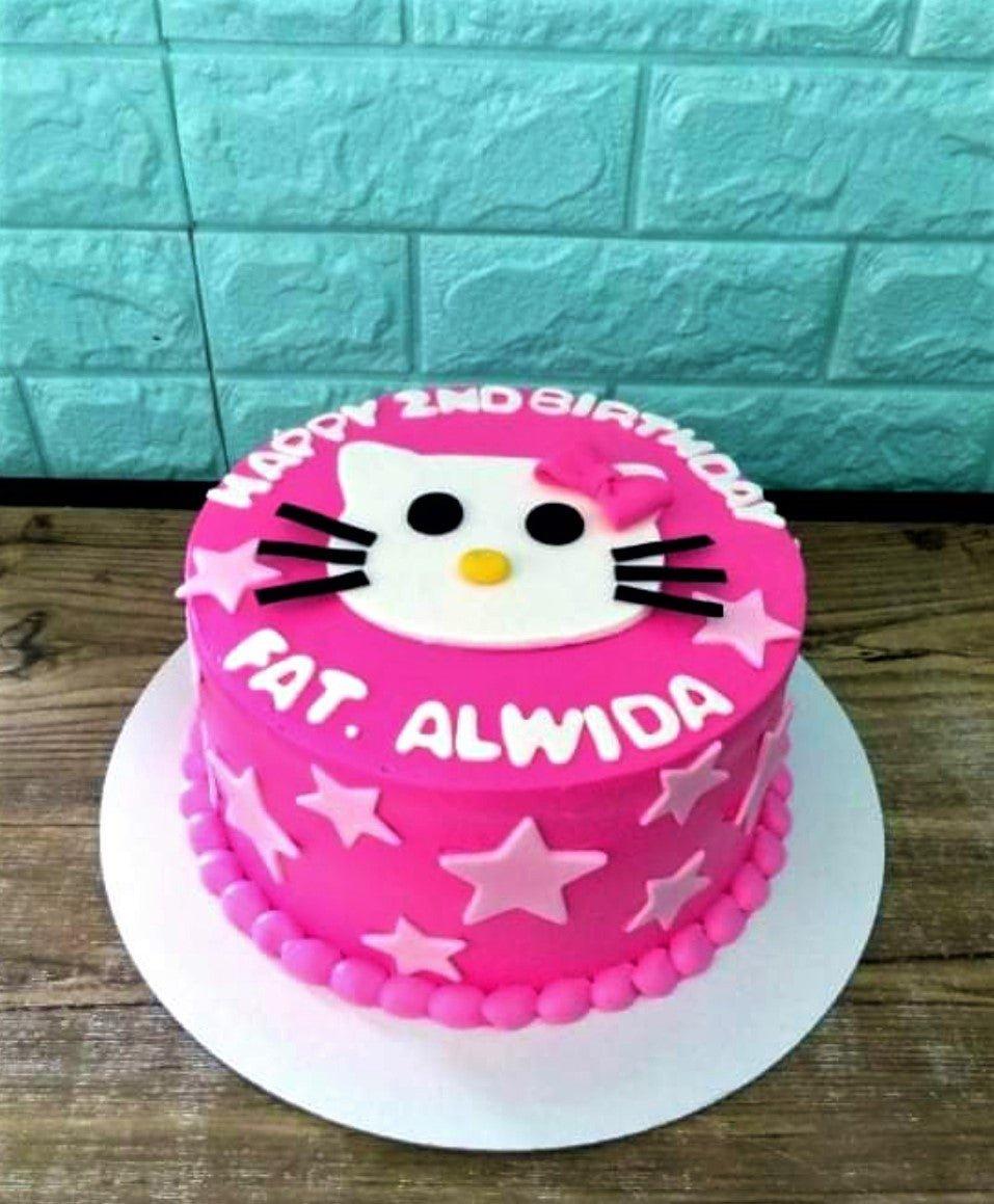 Pink Hello Kitty themed birthday cake with white fondant face and pink stars