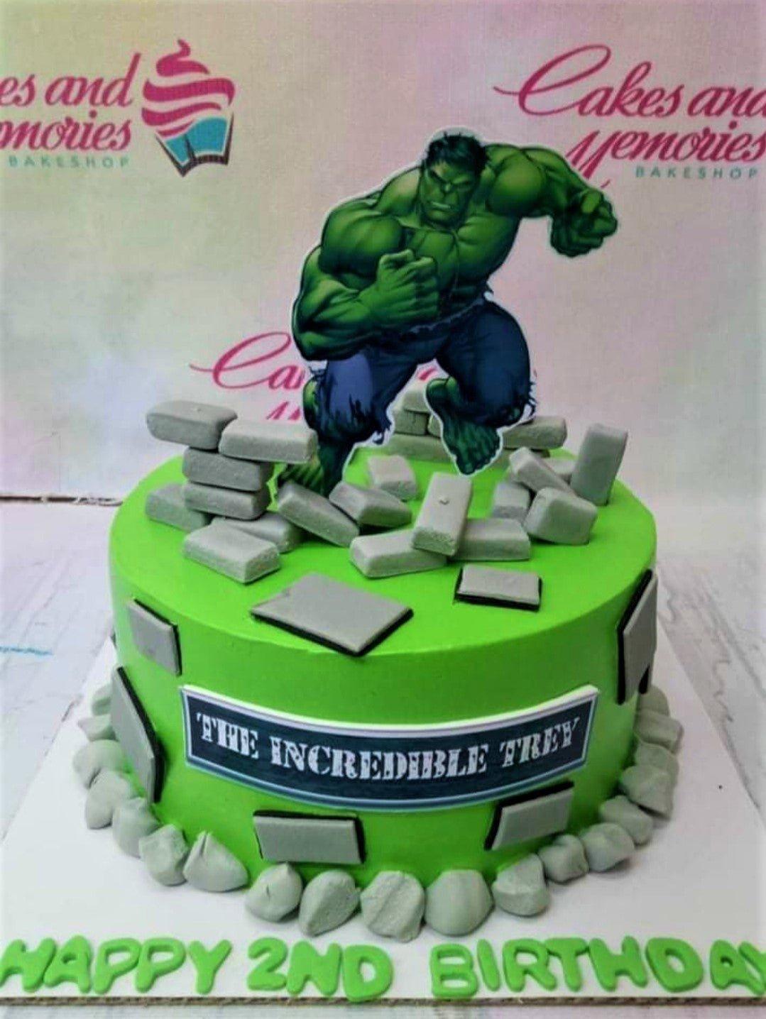 Green Hulk themed birthday cake with grey fondant bricks and a Hulk character printout topper.