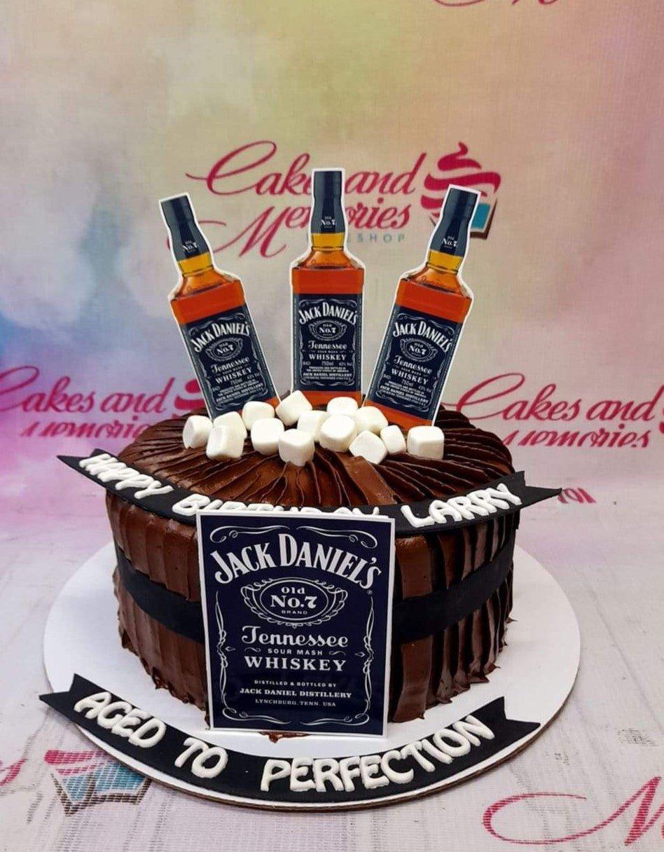 Chocolate birthday cake for Larry featuring Jack Daniel's whiskey bottle printouts and white marshmallows on a dark chocolate base.