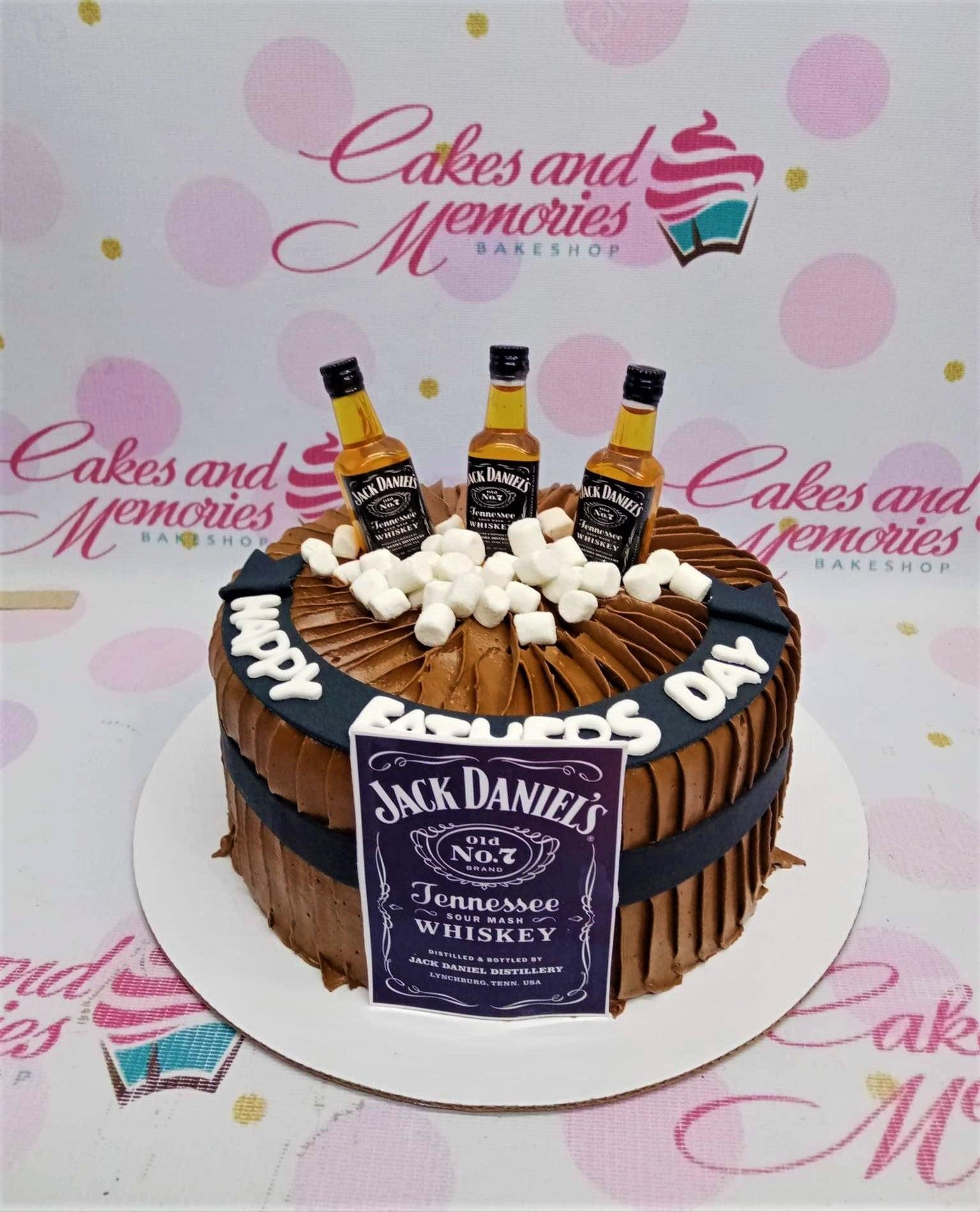 Chocolate Father's Day cake with Jack Daniel's whiskey bottles, marshmallows, and a black fondant banner.