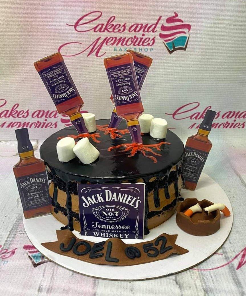 Jack Daniel's themed chocolate drip cake with whiskey bottle toppers, marshmallows, and a fondant ashtray for a 52nd birthday.