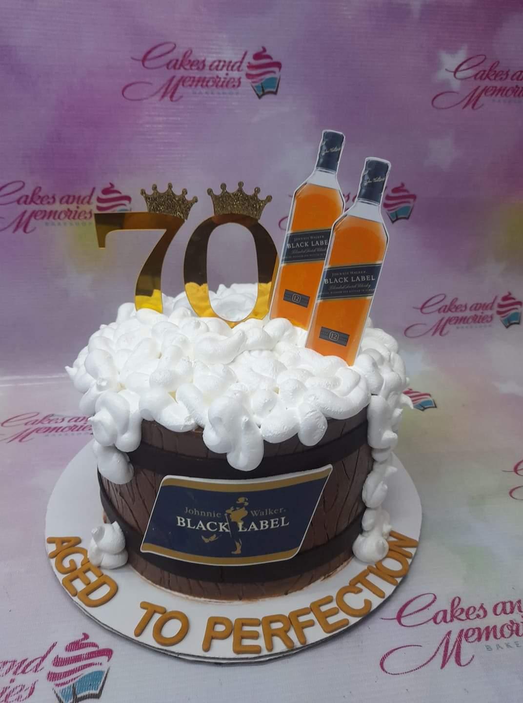 Johnnie Walker Black Label themed barrel cake with white icing foam and gold 70th birthday toppers.