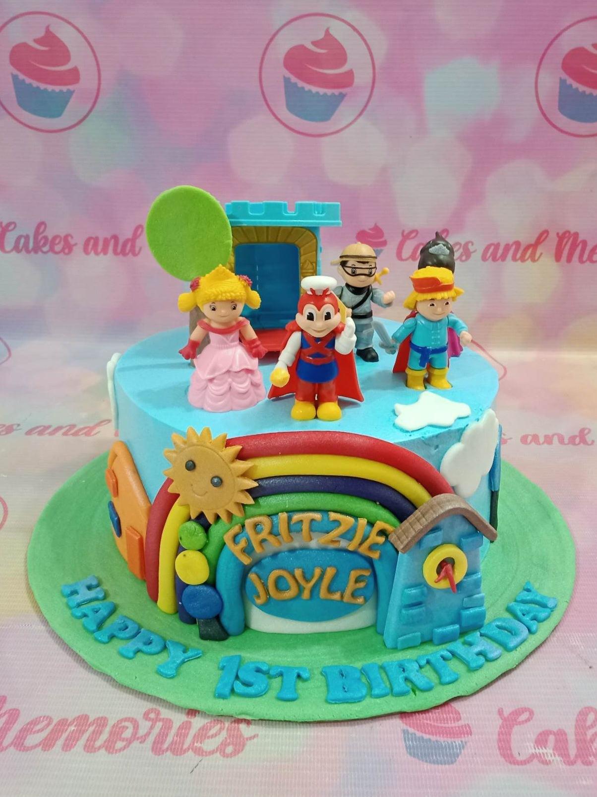 Jollibee and friends themed 1-tier fondant cake with a rainbow, sun, and character toys on a green base board.