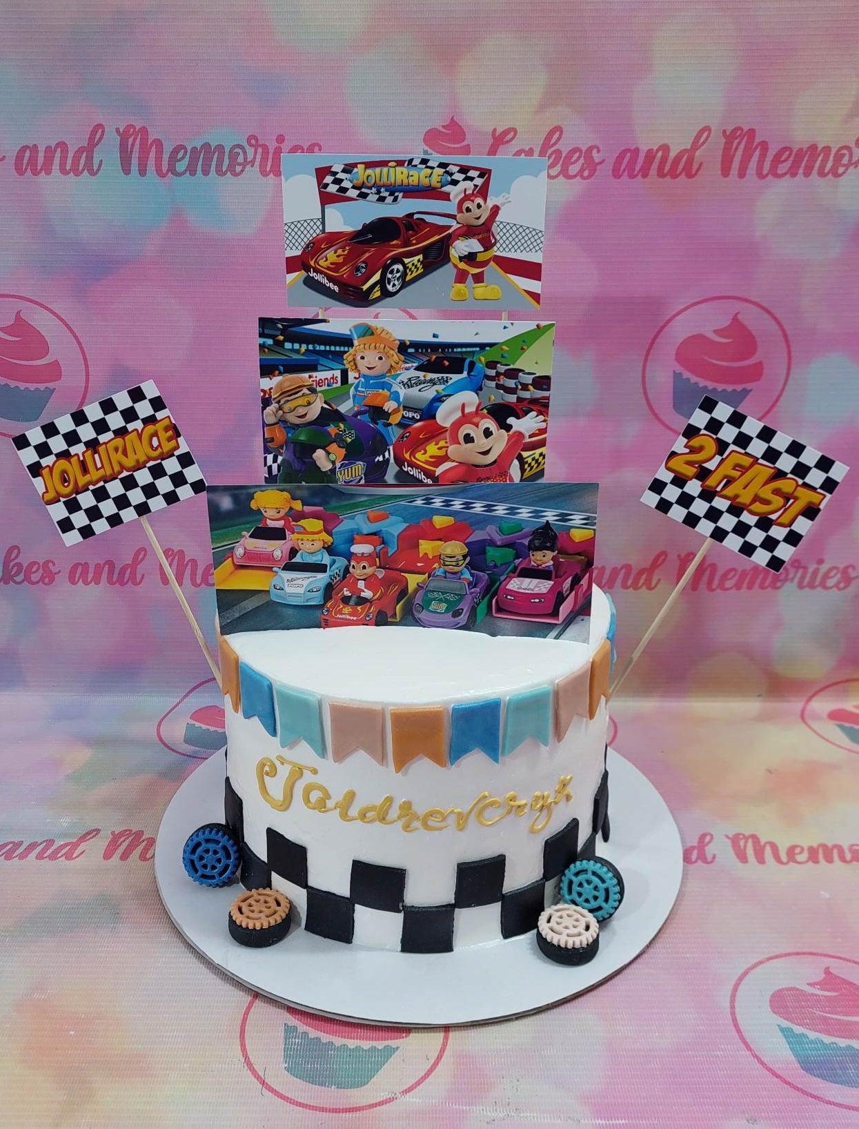 Jollibee Jollirace themed birthday cake with racing car printouts, checkered flags, and fondant gear decorations.