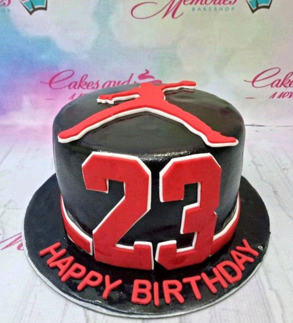 Black fondant cake with red and white Jordan Jumpman logo on top and number 23 on the side for a basketball themed birthday.