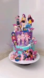 Two-tier K-pop themed birthday cake in purple and light blue with character printouts and musical note decorations.