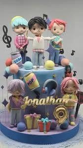 Two-tier blue and purple fondant cake featuring five 3D K-pop style boy band figurines with musical notes and soda can decorations.