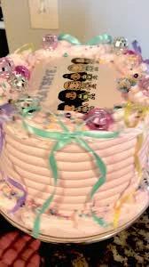 Pink soft-icing cake with Katseye K-pop group printout topper, teal ribbons, and disco ball decorations.