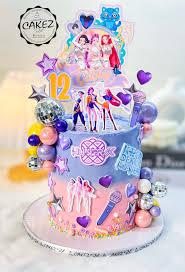 Purple and pink gradient cake with anime character printouts, disco balls, and purple hearts