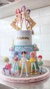 A grand 3-tier K-pop themed cake featuring seven detailed 3D figurines of boy band members and three female figurines on top.