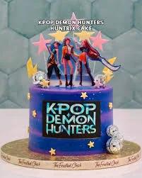 Purple and blue galaxy themed K-Pop Demon Hunters cake with character printouts and disco balls