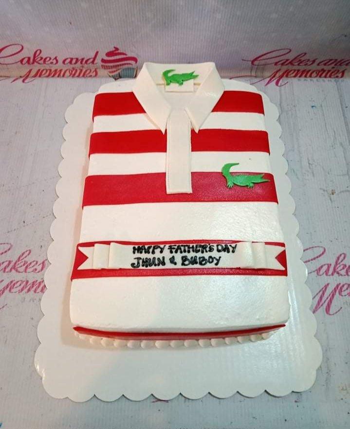 Lacoste polo shirt cake in red and white stripes with green crocodile logo and Father's Day message on a white scalloped board.