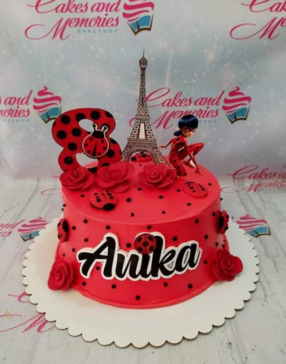 Red Ladybug themed birthday cake for Anika with Eiffel Tower and Ladybug character printouts and red fondant roses.