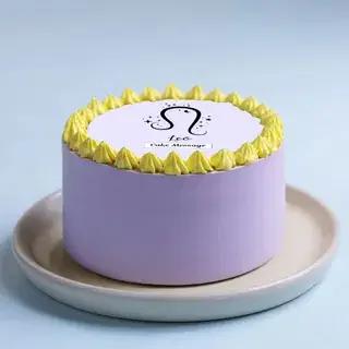 Purple bento cake with yellow icing rosettes and a Leo zodiac sign printout on top.