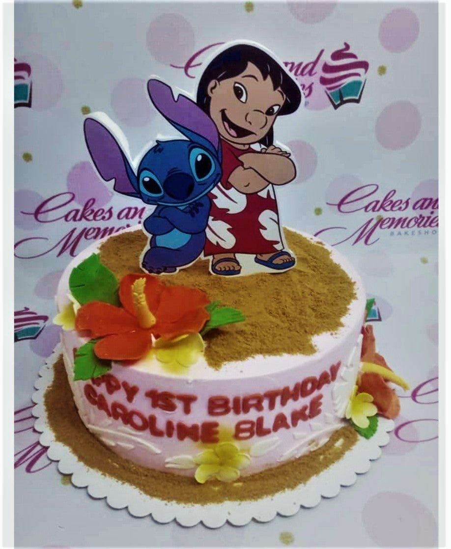 Lilo and Stitch themed birthday cake with pink icing, hibiscus flowers, and a large character printout topper.