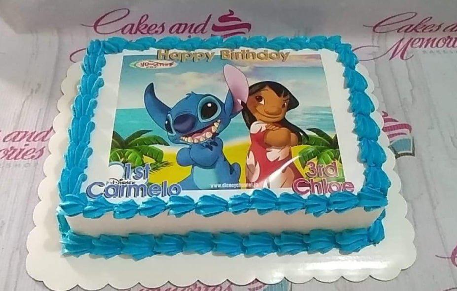 Rectangle Lilo and Stitch birthday cake with blue icing borders and a large character printout featuring Stitch and Lilo on a beach.