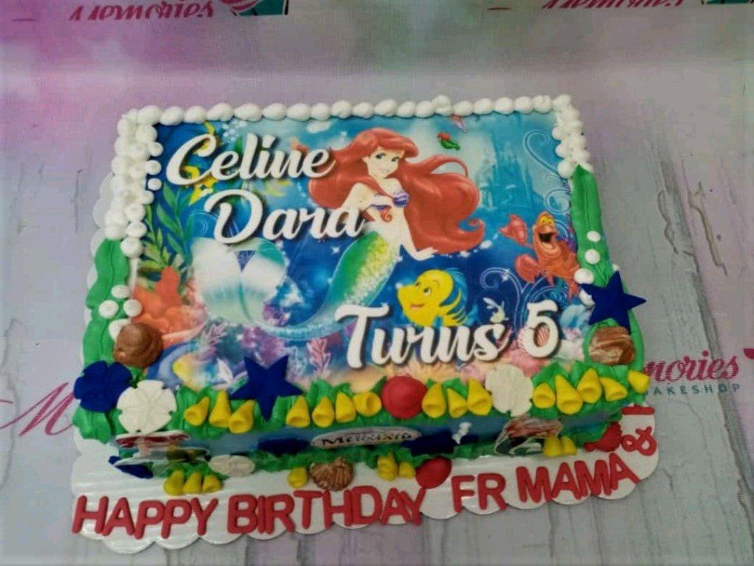 Rectangle Little Mermaid themed cake with Ariel printout, white icing borders, and colorful gumpaste sea decorations.