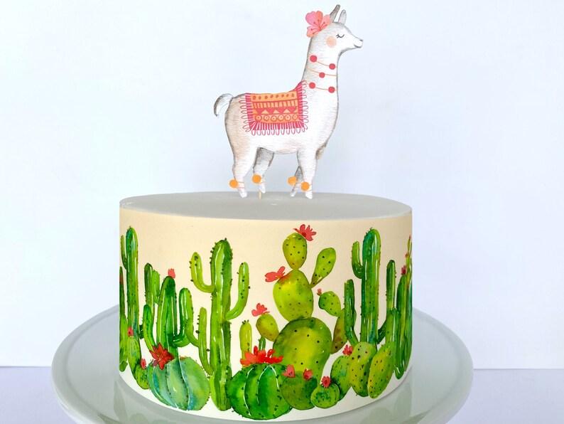 Single tier llama and cactus themed cake with a watercolor style llama topper and cactus side wrap on a beige base.