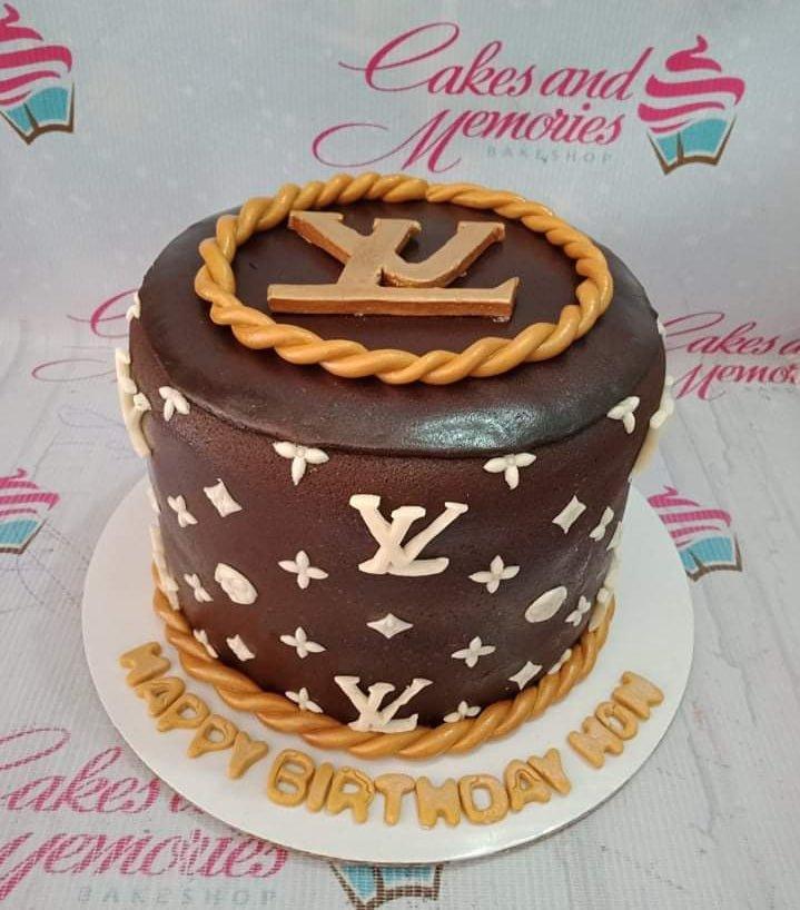 Brown Louis Vuitton themed fondant cake with white LV logos, gold rope borders, and a large gold LV topper.