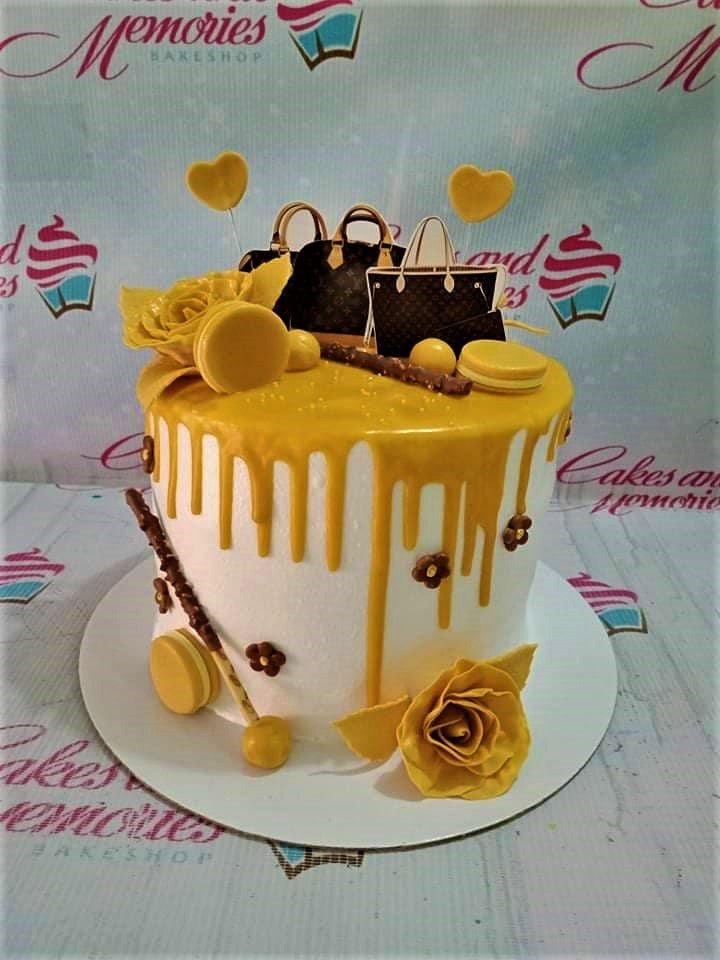 White 1-tier cake with yellow drip, yellow fondant roses, macarons, and Louis Vuitton bag printout toppers.