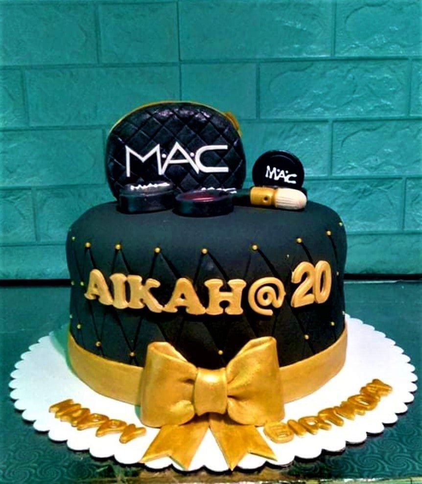 Black quilted fondant cake with gold MAC makeup toppers, a large gold bow, and personalized name Aikah at 20.