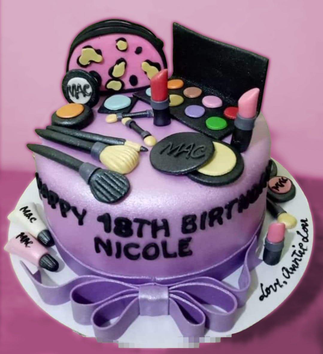 Purple fondant MAC makeup themed cake with edible 3D lipstick, brushes, and eyeshadow palette toppers.