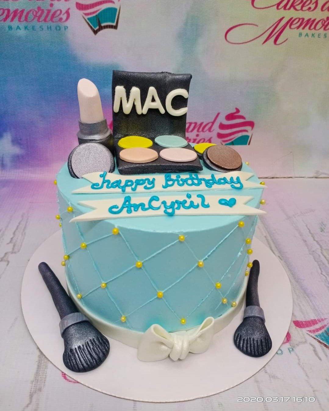 Light blue makeup themed birthday cake with fondant MAC eyeshadow palette, lipstick, and brushes with yellow pearl accents.