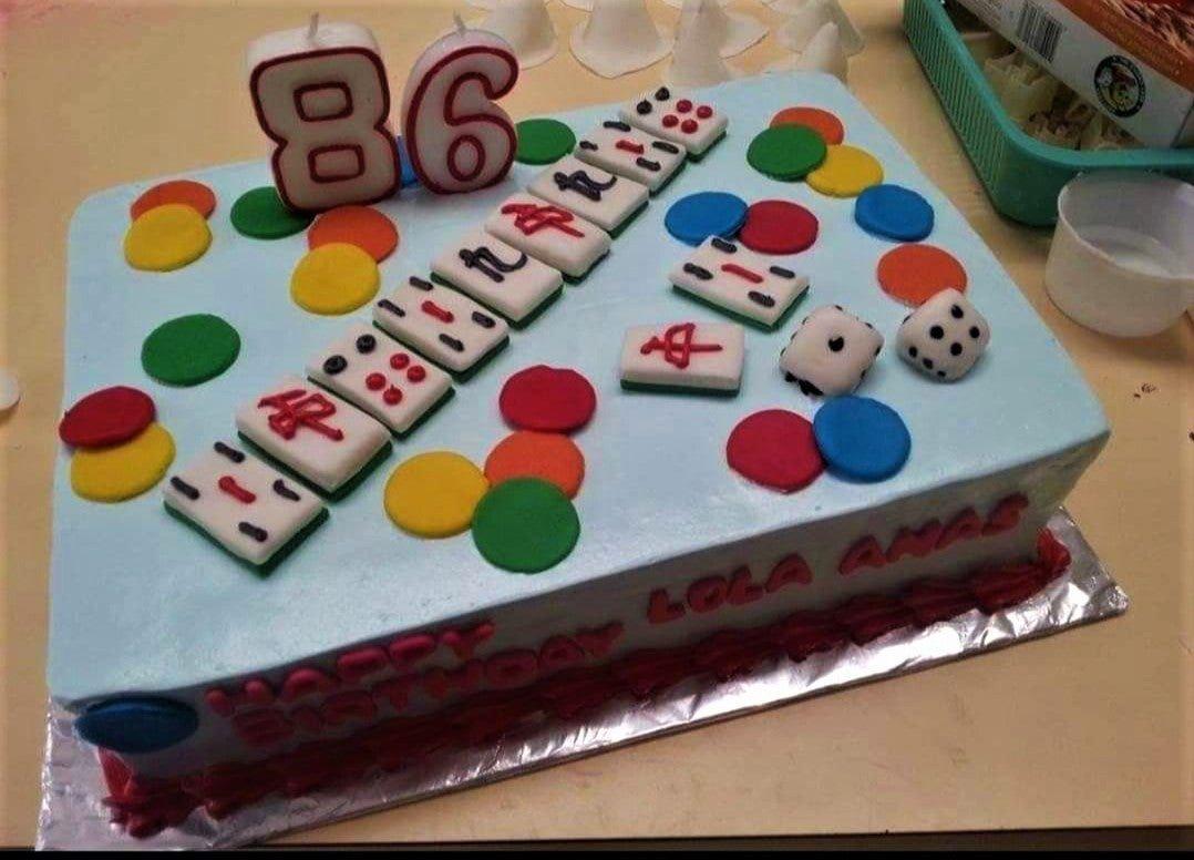 Light blue rectangular mahjong themed cake with edible tiles, dice, and colorful fondant circles for an 86th birthday celebration.