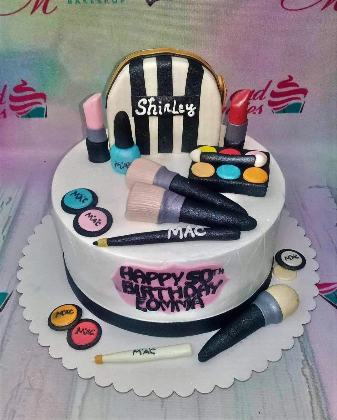 White fondant makeup themed cake with edible 3D lipstick, brushes, and eyeshadow palette toppers for a 50th birthday.