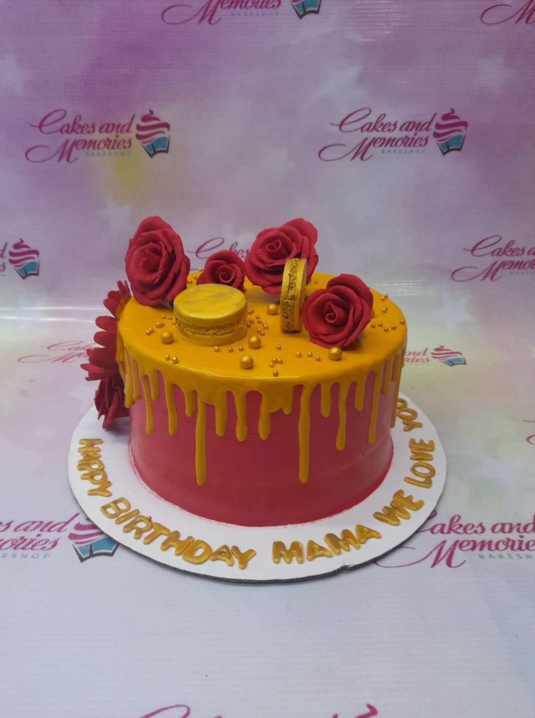 Red and yellow 1-tier birthday cake for Mama with red edible roses, a gold macaron, and gold dragees.