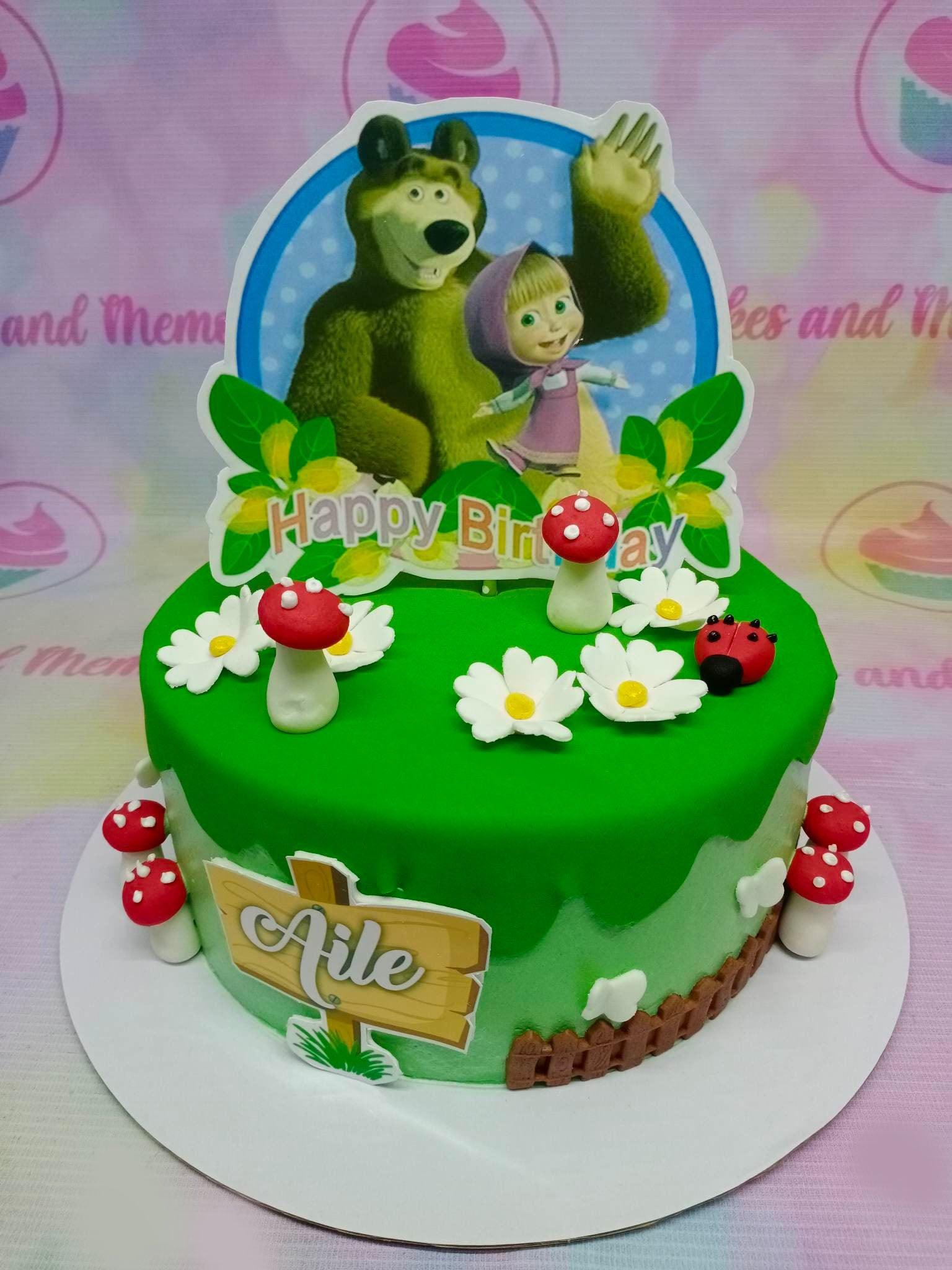Masha and the Bear themed green fondant cake with edible mushrooms, flowers, and a ladybug topper.