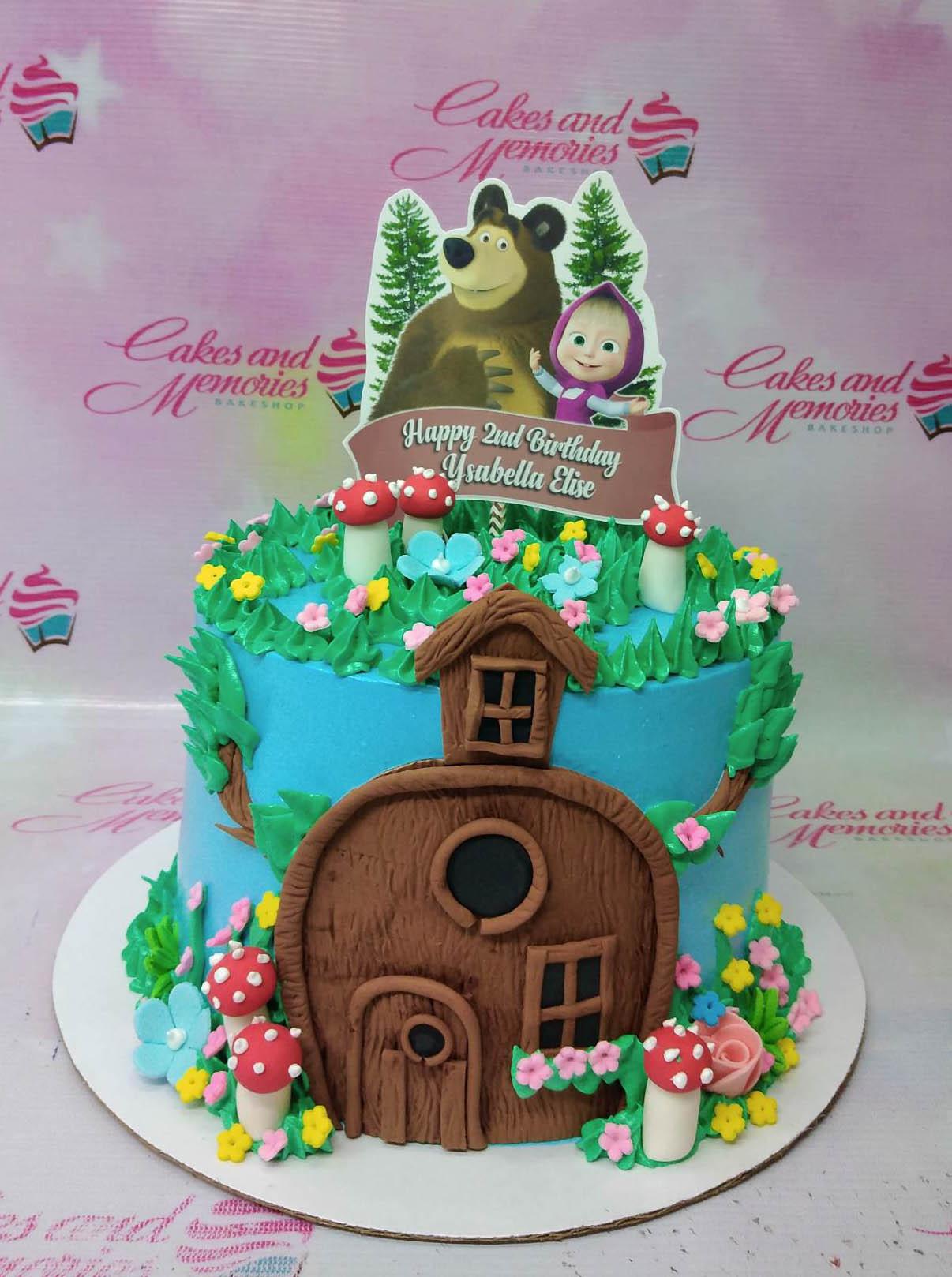 Masha and the Bear themed blue cake with a fondant house, mushrooms, and character printouts.