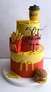 Two-tier McDonald's themed cake with fondant burger, fries, and McCafe cup toppers in red and yellow.